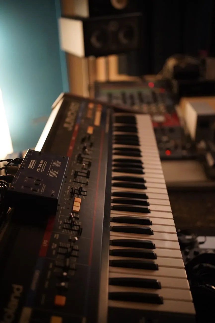 Close up of a vintage synthesizer keyboard in a dimly lit professional music stu